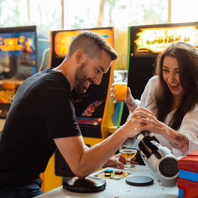 Couple playing arcade games during engagement photoshoot in Vermont