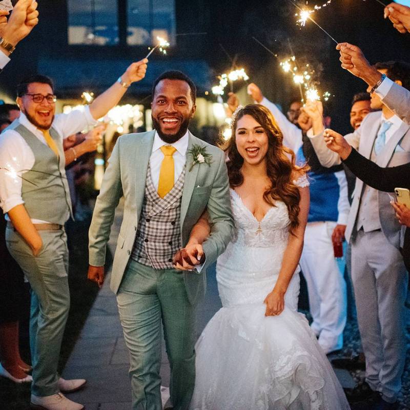 BIPOC couple walking through sparkler exit at Vermont wedding