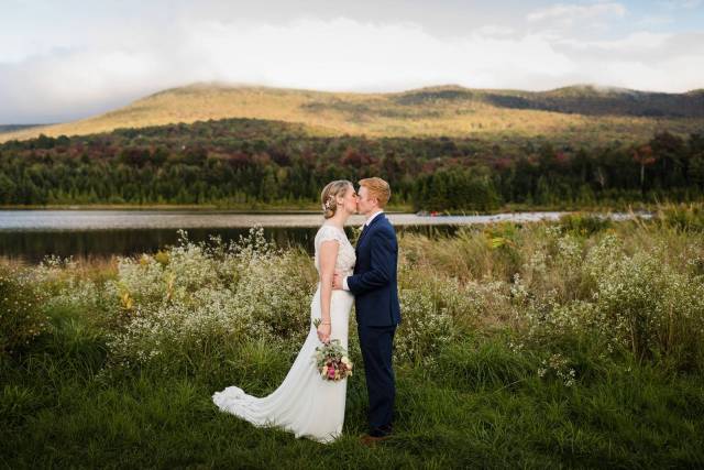 Bride and groom kissing in the field of Vermont during elopement