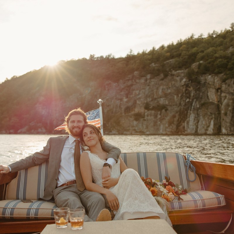 Couple sitting on boat on wedding day at sunset on Lake Champlain in Vermont