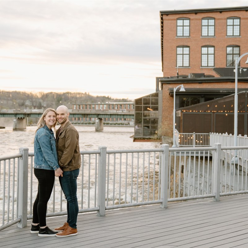 Couple smiling for engagement shoot in downtown Winooski, VT