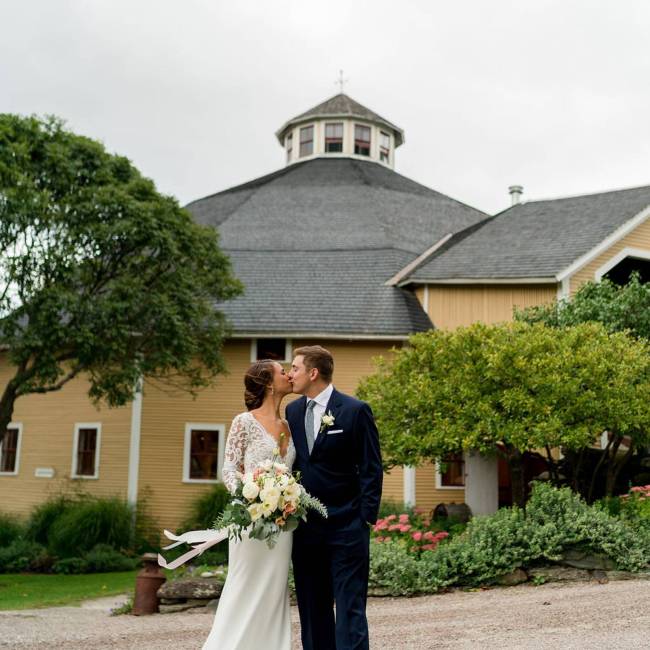 Photo of bride and groom standing outside the Inn at the Round Barn Farm on wedding day in Waitsfield, Vermont