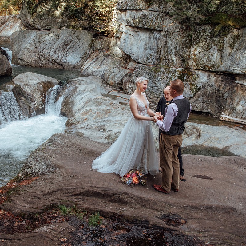 A photo of a couple's elopement ceremony at Warren Falls, Vermont