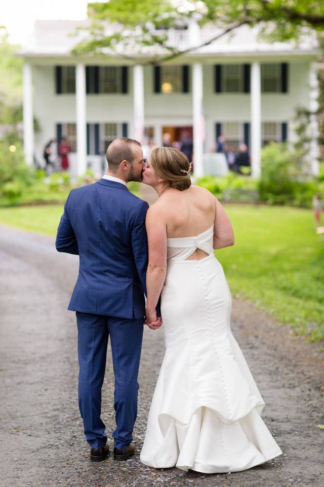 Bride and groom kissing on the front lawn of the Inn at Weathersfield during Vermont wedding