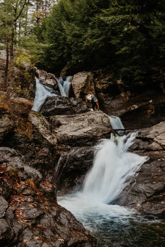 couple at a waterfall for adventurous engagement session