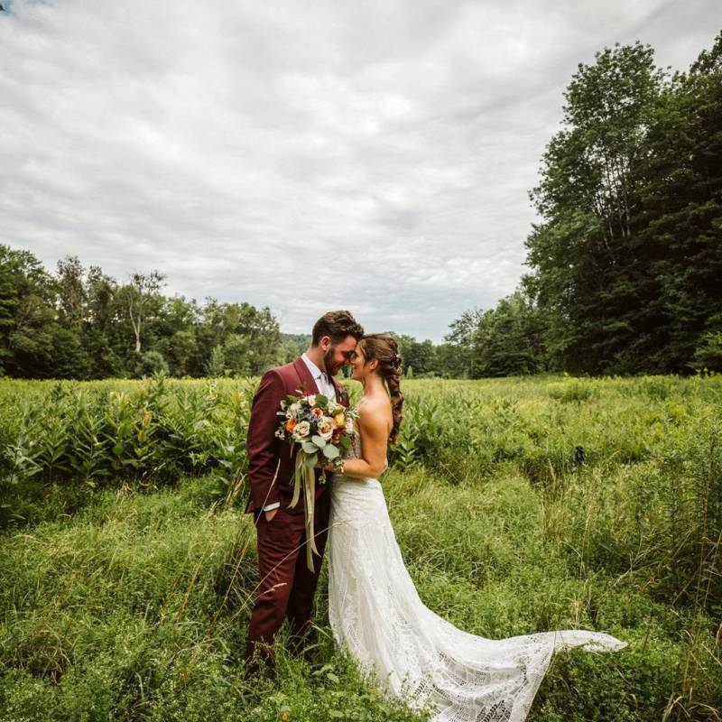 White couple kissing in lush Vermont field