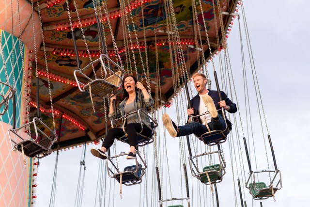 adventurous engagement session couple on the swings