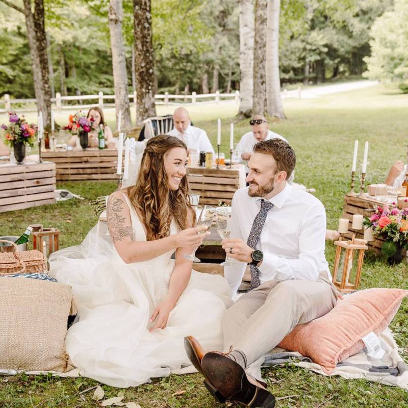 White couple cheersing during picnic wedding reception in Vermont