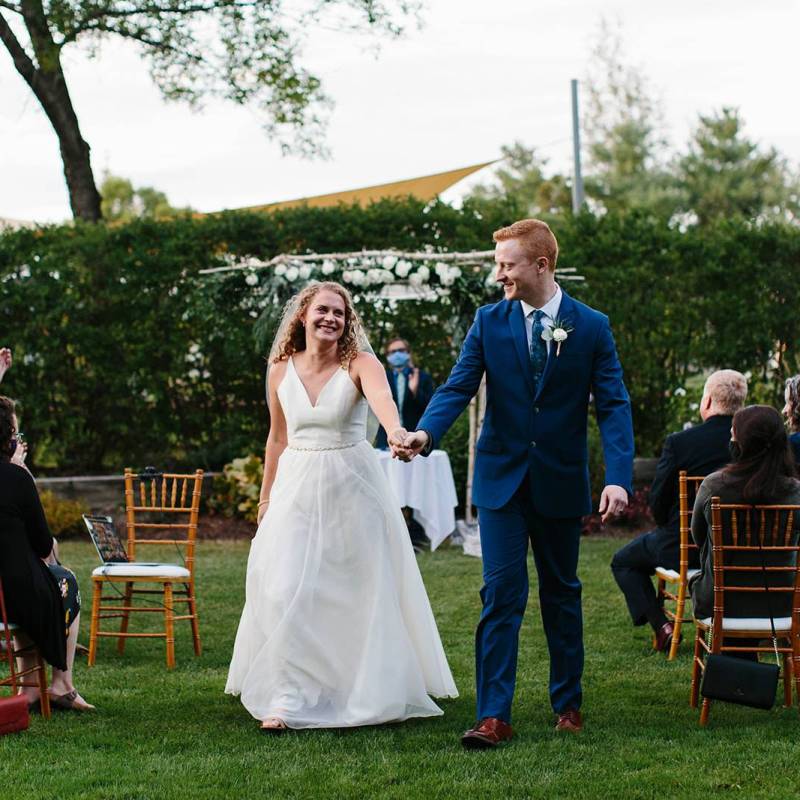 White bride and groom walking down aisle after outdoor wedding ceremony at the Essex Resort in Vermont