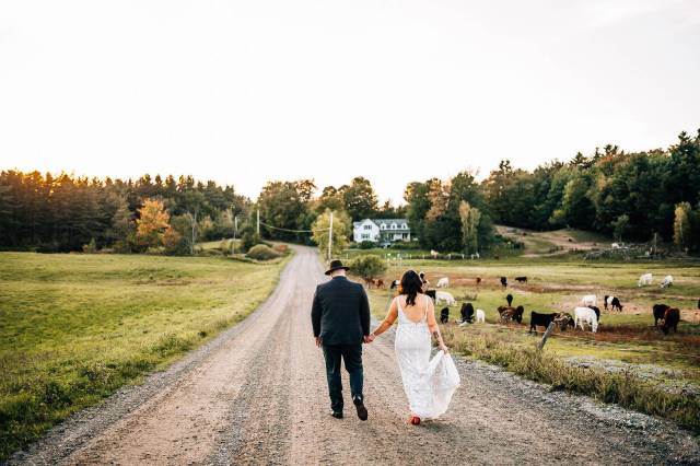Bride and groom walking down country road in Vermont in the fall