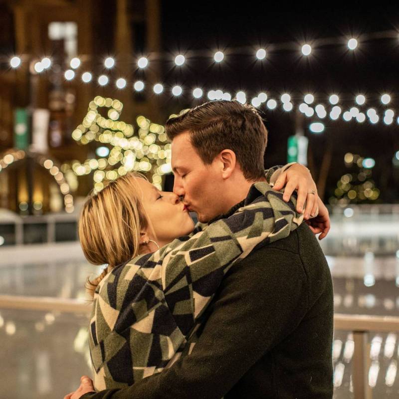 Couple kissing on the ice rink after surprise proposal in Stowe Vermont